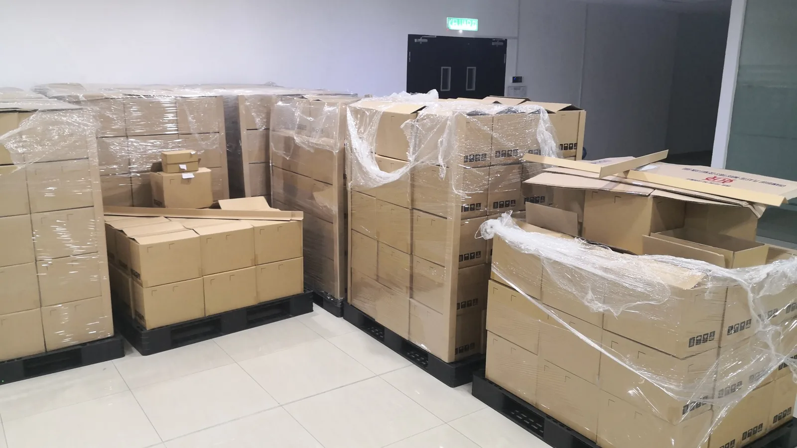 Shrink-wrapped pallets of cardboard cartons received into a storeroom