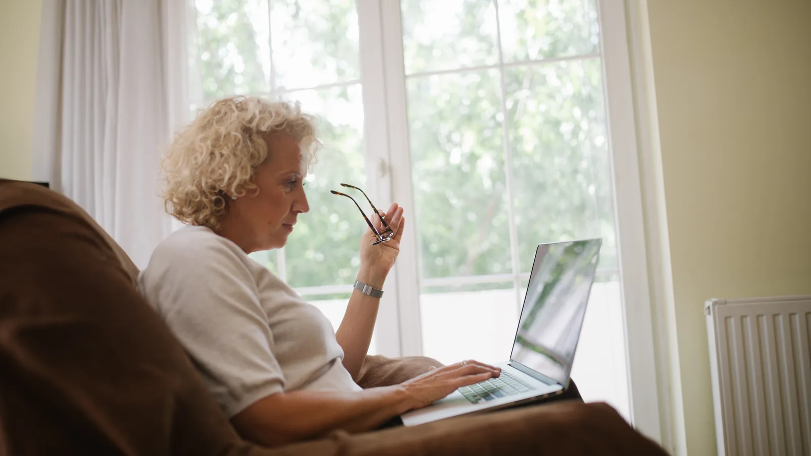 A woman typing on a laptop at home while reading and replying to work email