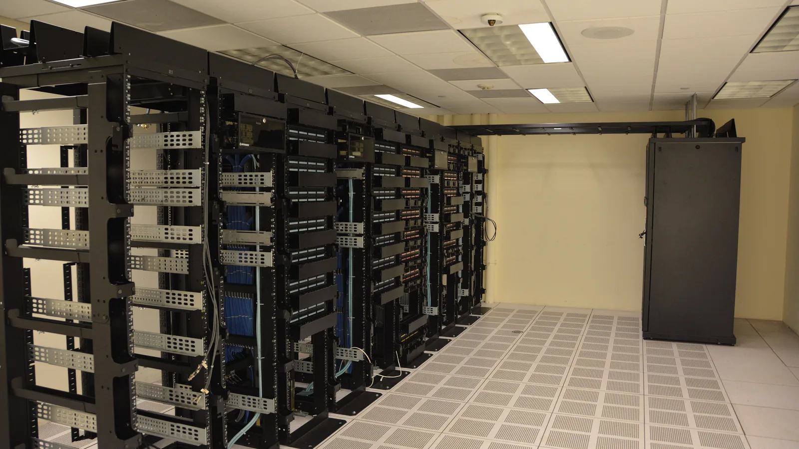 Rows of network and server racks in a data centre room