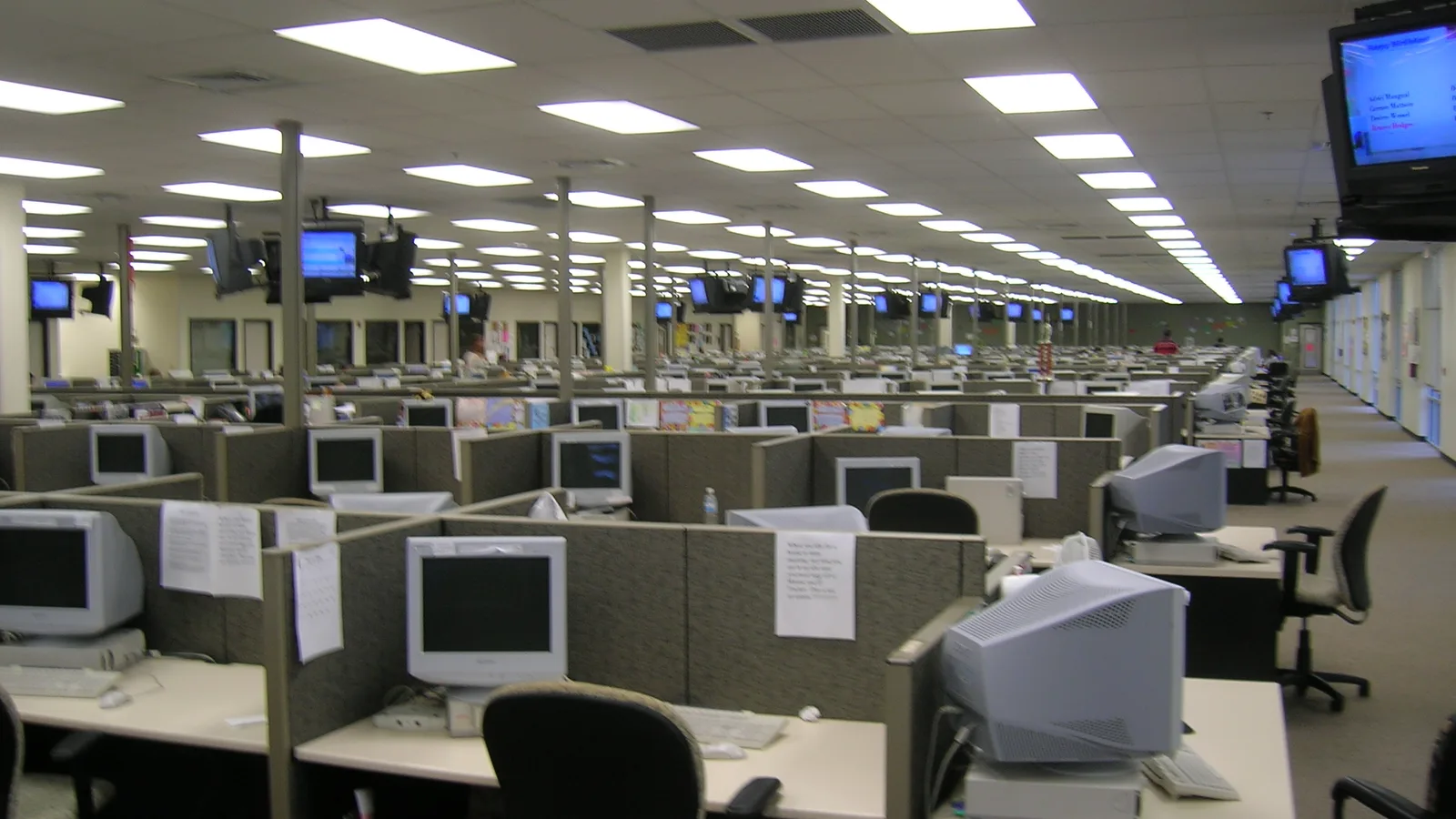 Large contact centre floor with rows of agent workstations and wallboards