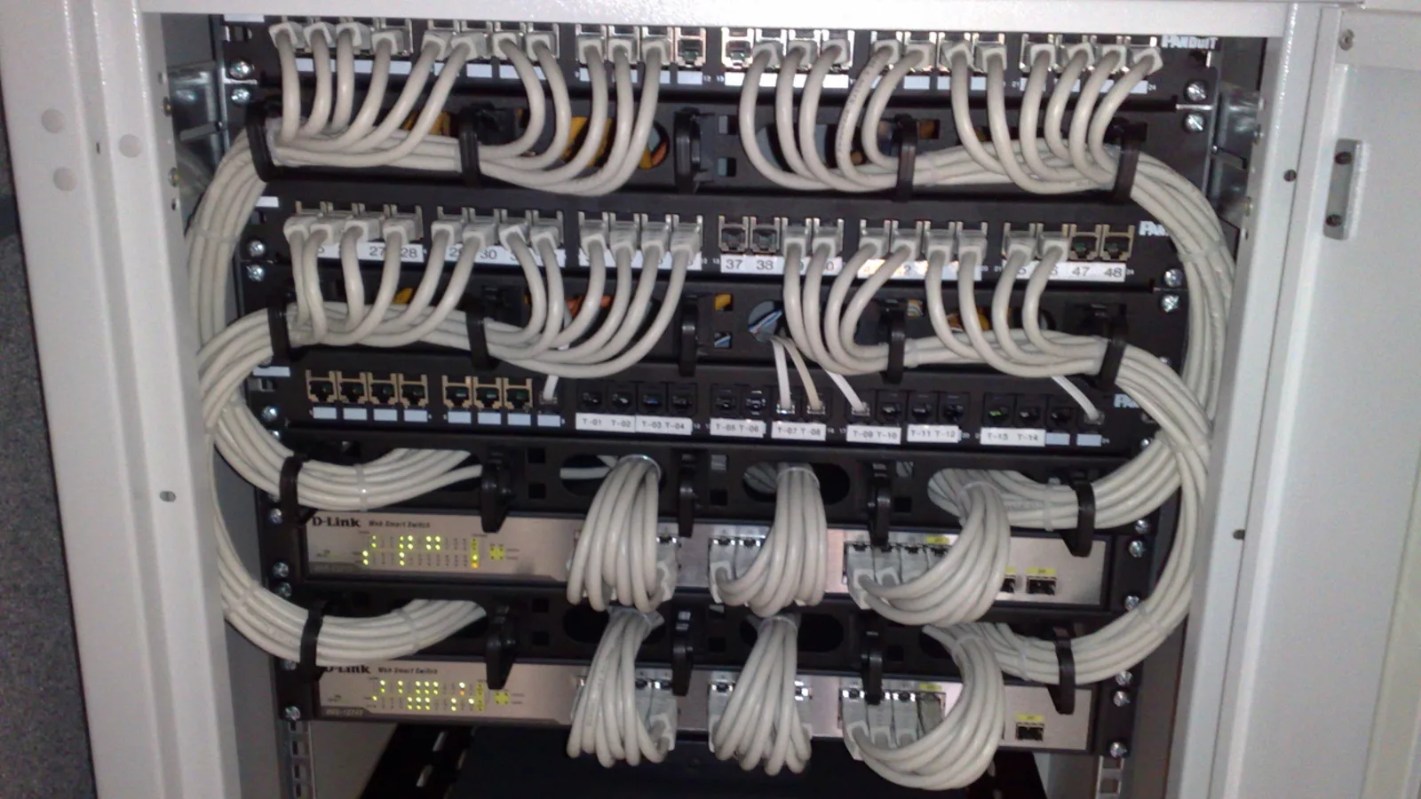 Rack-mounted network switches and patch panels with neatly routed Ethernet cables
