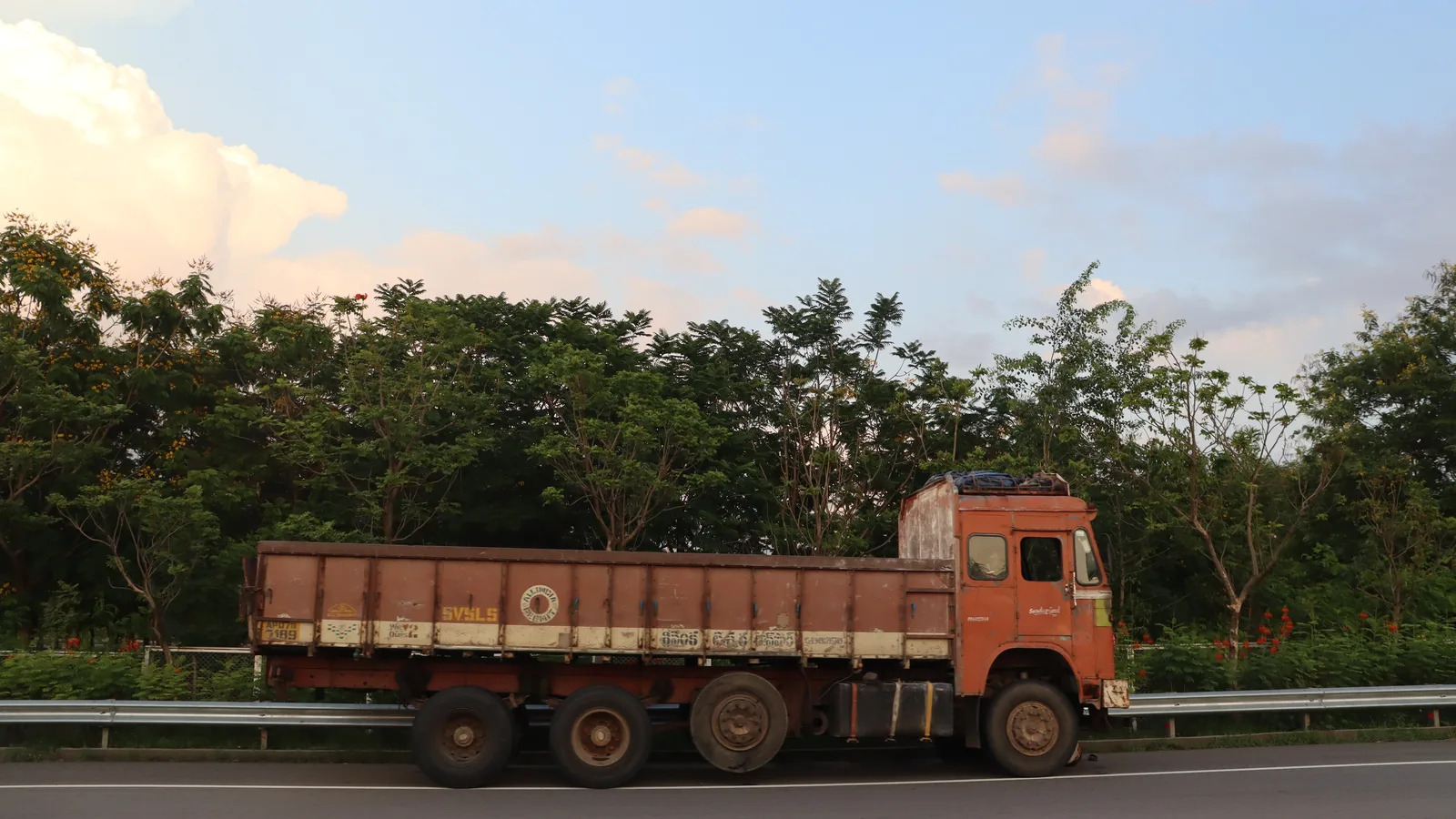 Multi-axle goods truck parked beside an Indian highway