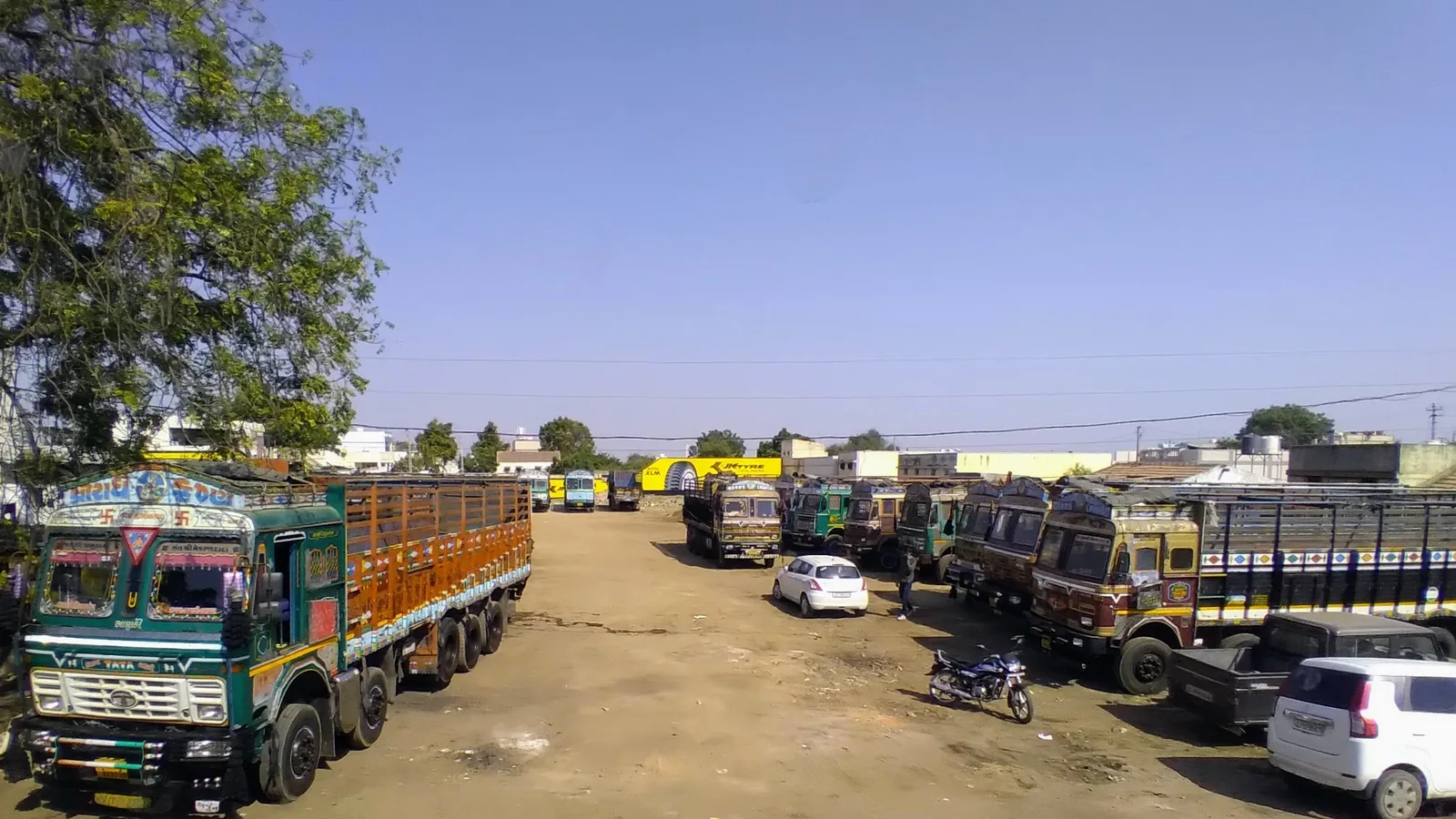 Rows of decorated Indian goods trucks parked at a transport yard in Ratnal