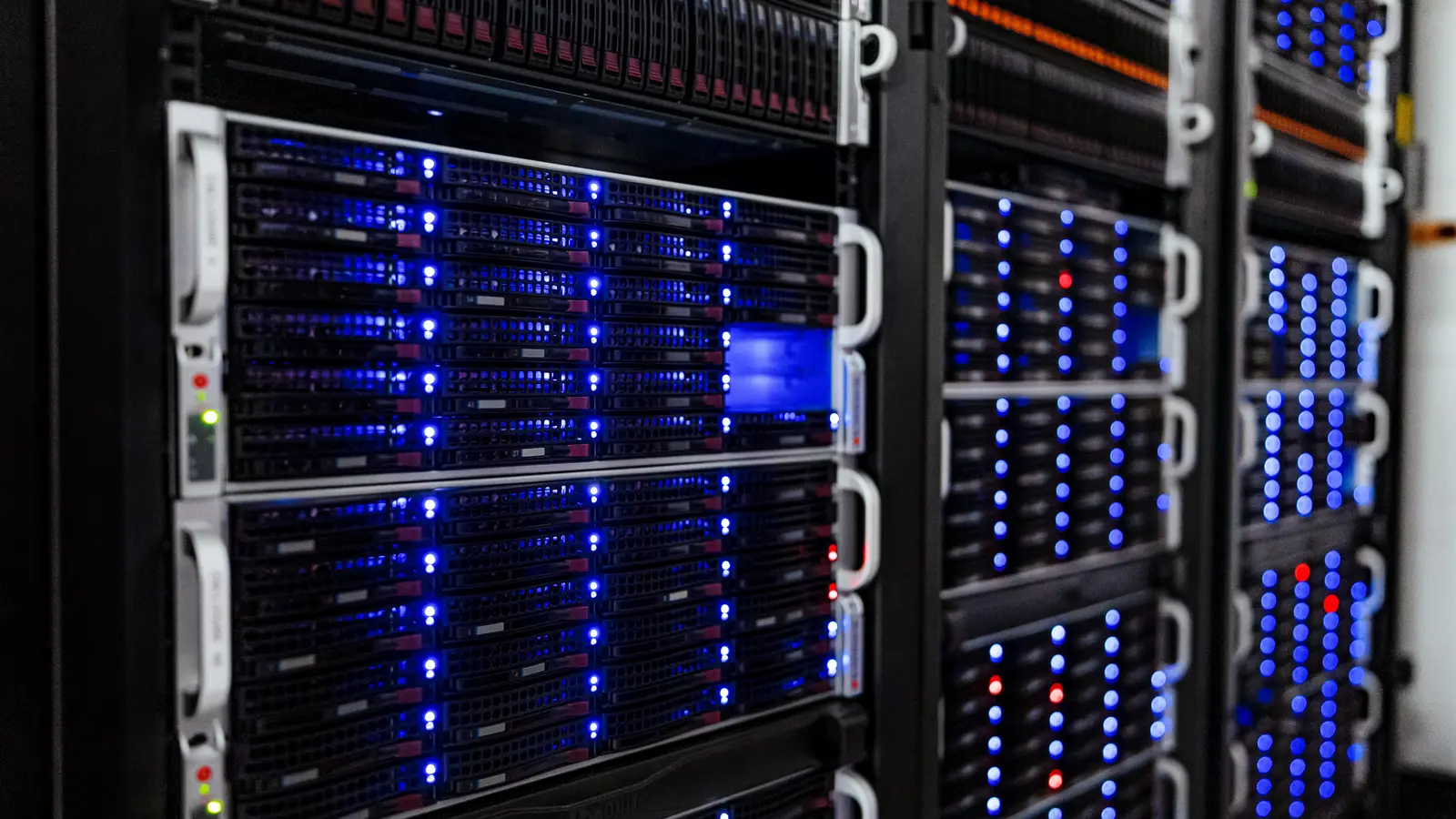 Server racks with blue status lights in a data centre — the backbone of modern business IT infrastructure