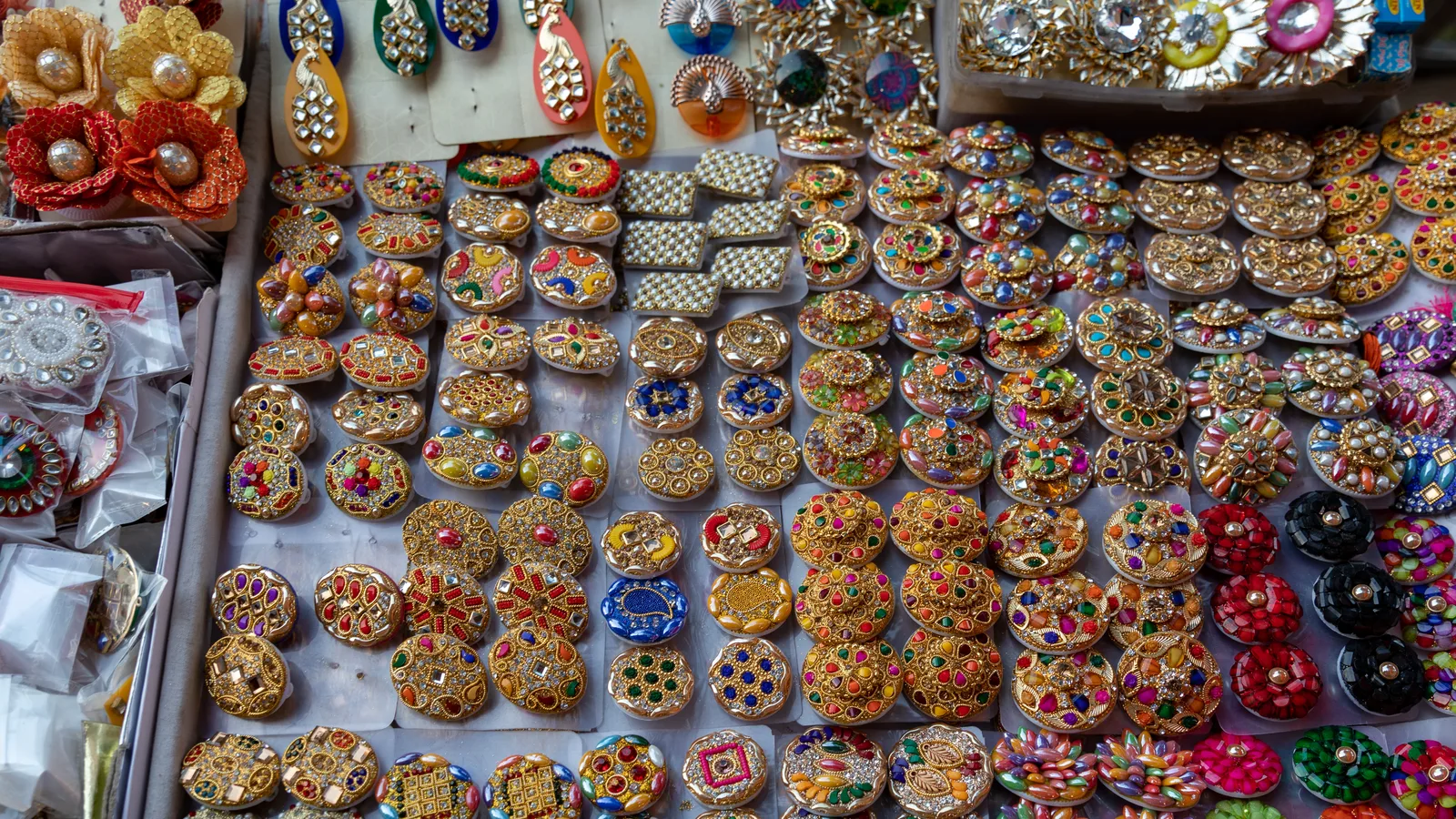 Trays of ornate gold-toned rings set with coloured stones on display at a jewellery shop in Jaipur