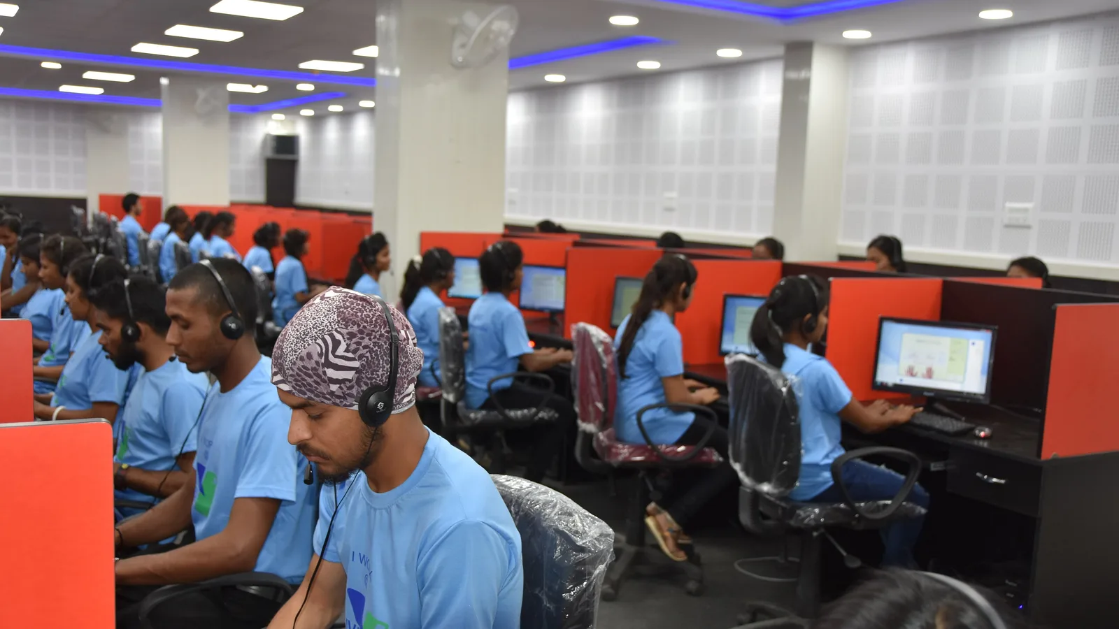 Rows of call centre agents wearing headsets at computer workstations in a BPO in Dantewada, Chhattisgarh