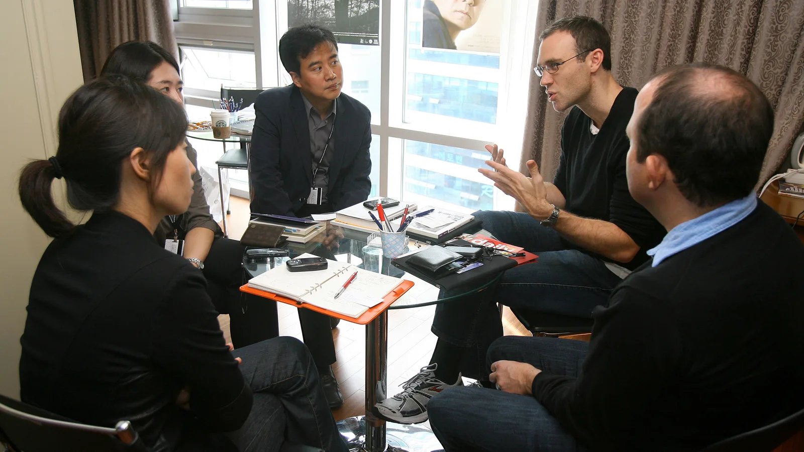 Small team discussing work around a meeting table