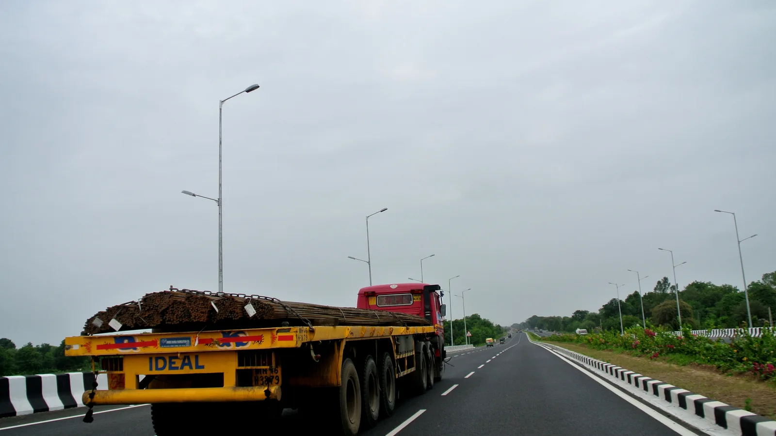 Flatbed truck carrying steel bars on an Indian expressway