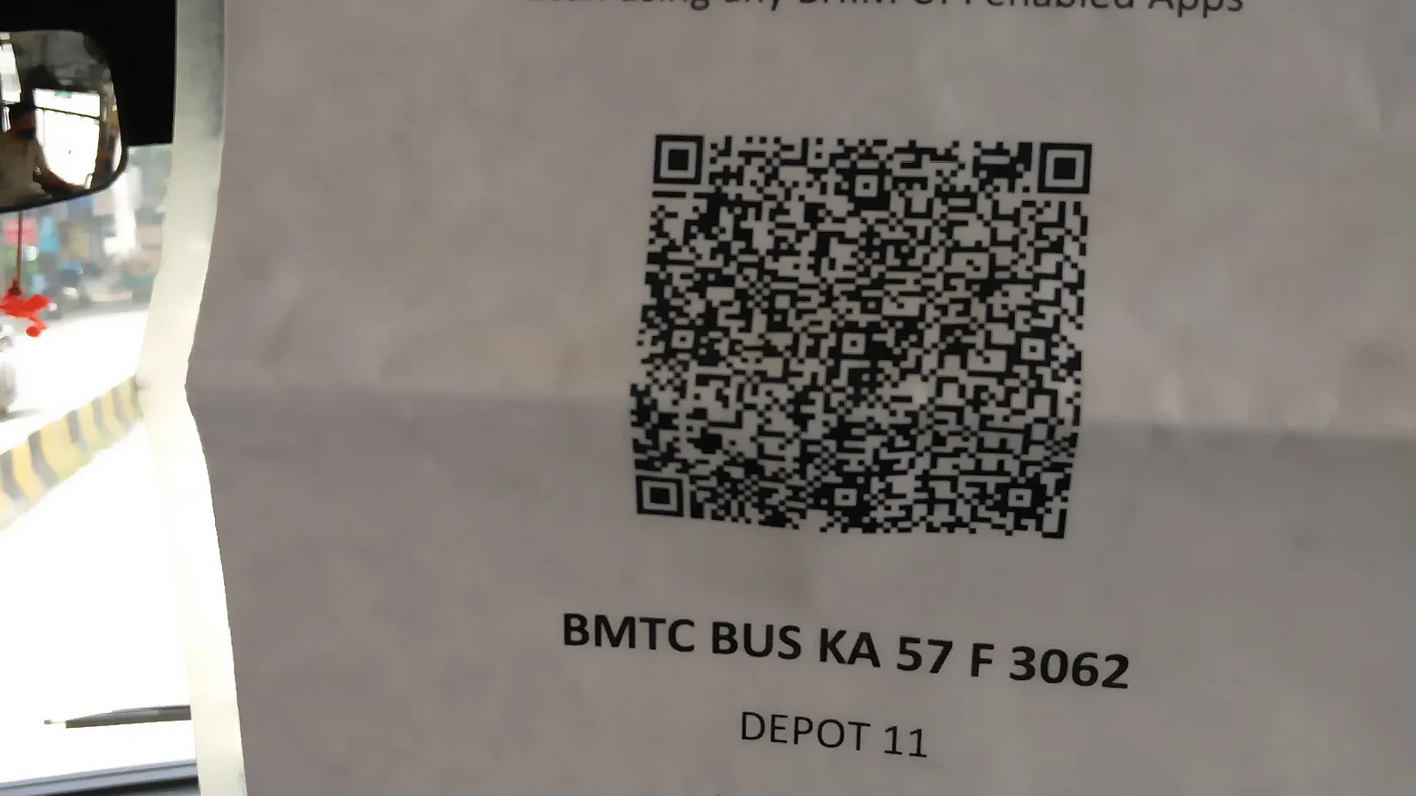 A printed UPI QR code sheet displayed inside a BMTC bus in Bengaluru for ticket payments